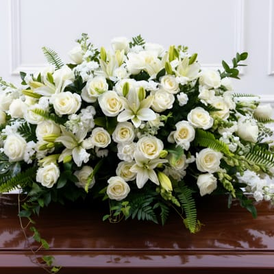 White floral casket spray with roses and lilies