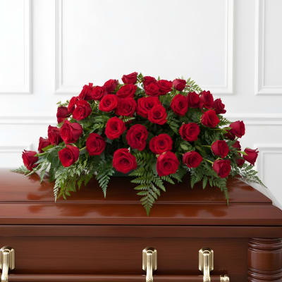 Red rose casket spray on a wooden coffin