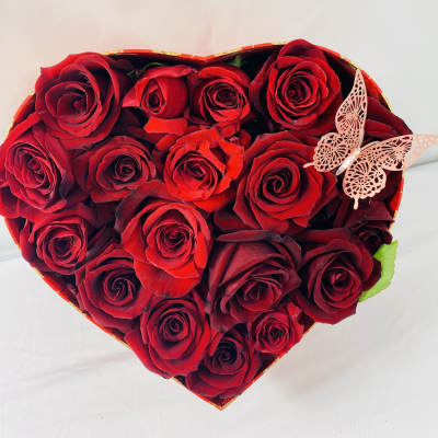 Heart-shaped box of red roses with a butterfly decoration