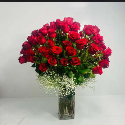 Bouquet of red roses in a clear glass vase with white baby's breath