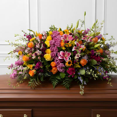 Large mixed floral spray on a wooden casket