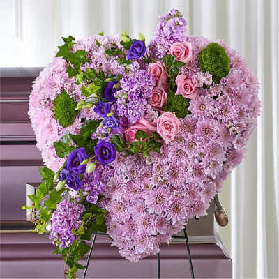 Heart-shaped floral spray with pink and purple flowers on a stand