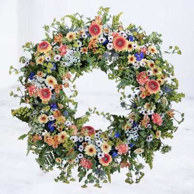 Circular floral wreath with mixed colorful flowers on a white background