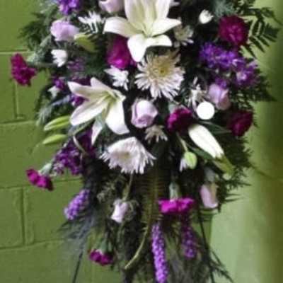 Tall standing floral spray with white lilies and purple flowers