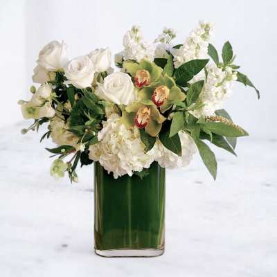 White roses and hydrangeas in a green glass vase