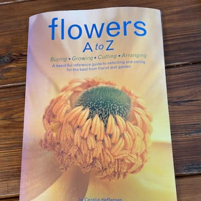 A book titled "flowers A to Z" on a wooden surface