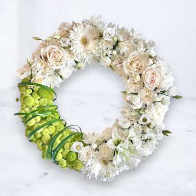 Circular floral wreath with white and cream blooms and a bright green section