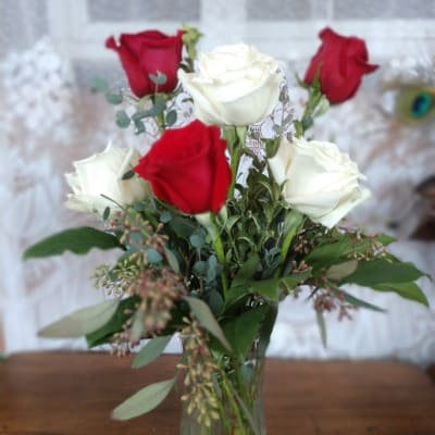 Red and white roses arranged in a clear glass vase