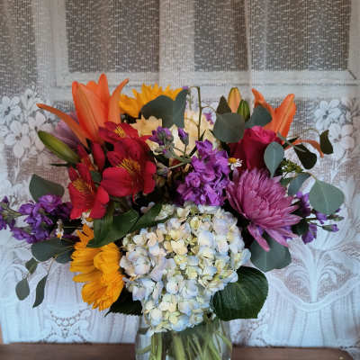 Mixed bouquet of colorful flowers in a clear glass vase