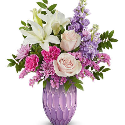 Pink and white flowers arranged in a purple vase