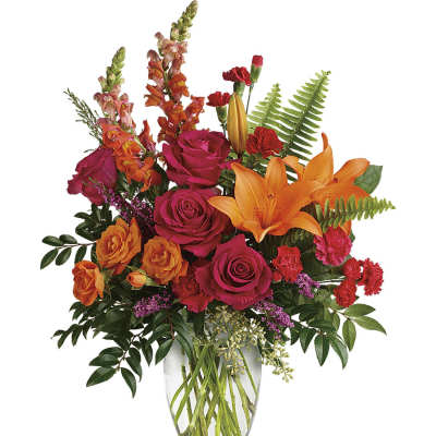 Bouquet of orange lilies and pink roses in a clear glass vase