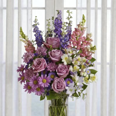 Mixed purple and pink flowers in a clear glass vase