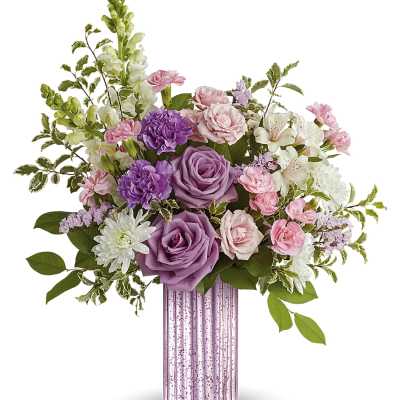 Lavender and pink flower arrangement with roses and carnations in a tall pink glass vase