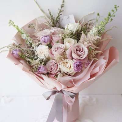Pink and white rose bouquet wrapped in pale pink paper