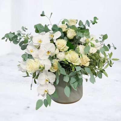 White orchids and cream roses in a gray vase