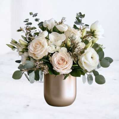 White and blush flowers arranged in a gold vase