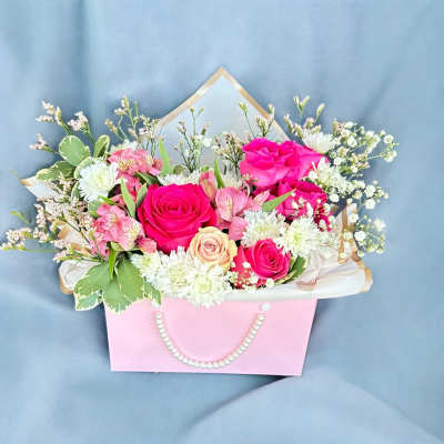 Pink and white flower bouquet in a pastel gift bag