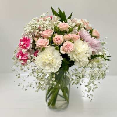 Bouquet of pale pink and white flowers in a clear glass vase