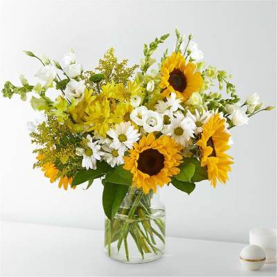 Sunflowers and white daisies in a clear glass vase