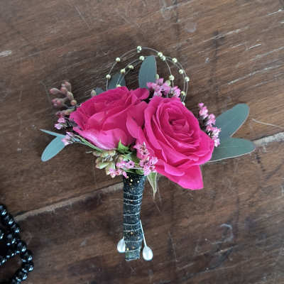 Pink rose boutonniere with small filler flowers and eucalyptus