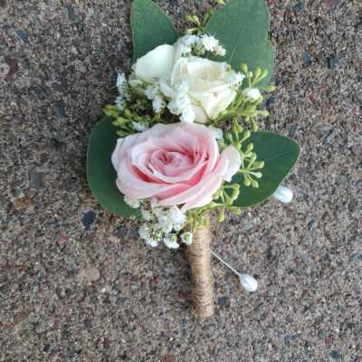 Small boutonniere with pink and white roses and green leaves