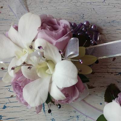 Pink roses with white orchids and ribbon accents