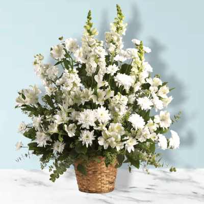 White mixed flower arrangement in a woven basket