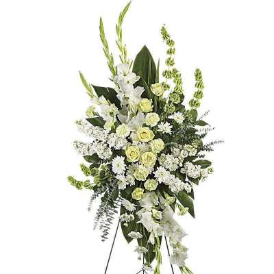 Tall white and pale green funeral spray on a stand