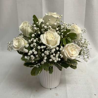 White roses and baby's breath in a white vase