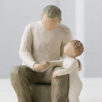 Wooden figurine of an adult and child sitting together