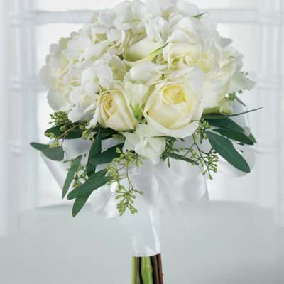 White rose and hydrangea bouquet with green foliage wrapped in white ribbon