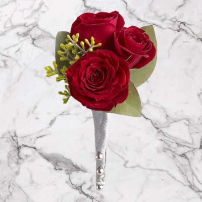 Three red roses in a silver-wrapped boutonniere