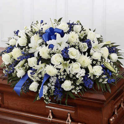 White and blue floral casket spray with ribbon accents