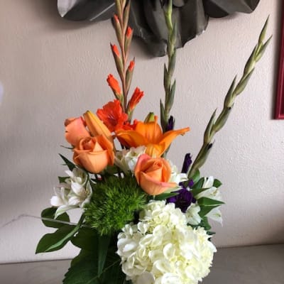 Orange roses and white hydrangea in a glass vase