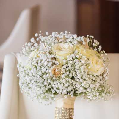 White rose bouquet with baby's breath and a jeweled handle wrap