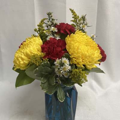 Yellow and red flowers arranged in a blue vase