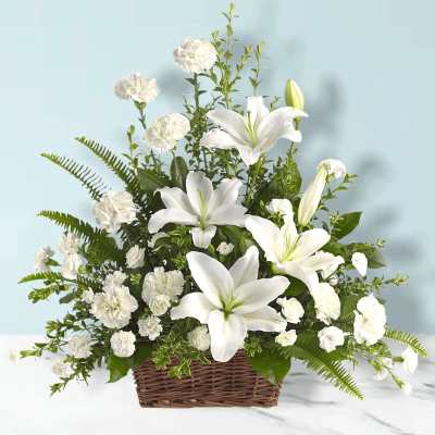 White lilies and carnations in a wicker basket