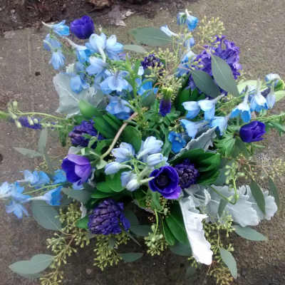 Compact bouquet of deep purple and blue flowers arranged in a rounded cluster