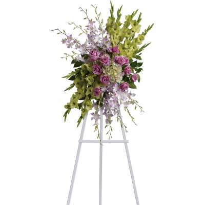 Standing floral spray with purple roses and green orchids on an easel