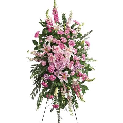 Tall pink floral standing spray with lilies and roses on an easel