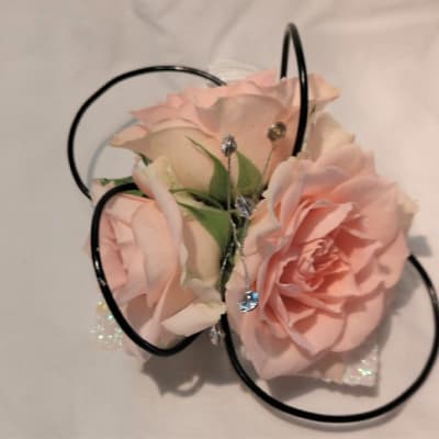 Pink rose corsage with black loops and small rhinestone accents