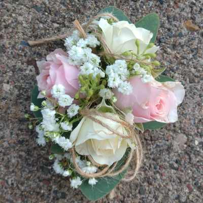 Small bouquet of pink and white roses with baby's breath tied with twine