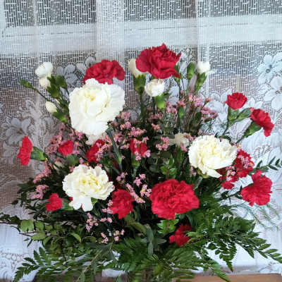 Red and white carnations arranged in a clear glass vase.