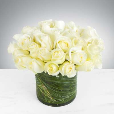 White roses arranged in a clear glass vase