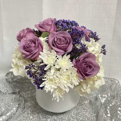 Lavender roses and white chrysanthemums in a white vase