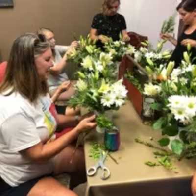 People arranging white lilies at a table