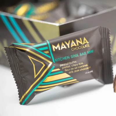 Wrapped chocolate bar with a cut piece showing caramel and nuts