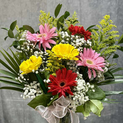 Bouquet of pink, red, and yellow gerbera daisies in a glass vase