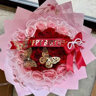 Pink and red rose bouquet with a birthday ribbon and butterfly decorations
