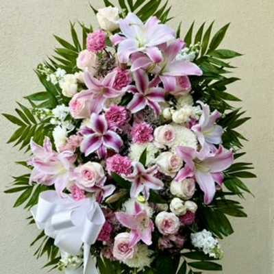Pink and white floral standing spray with a white ribbon